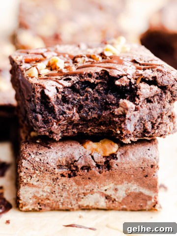 side super close up at a stack of two brownies with top one missing a bite.