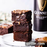 Guinness Chocolate Brownies with Rich Stout Flavor 17 stack of 3 chocolate Guinness brownies on a white plate with can of Guinness in a background.