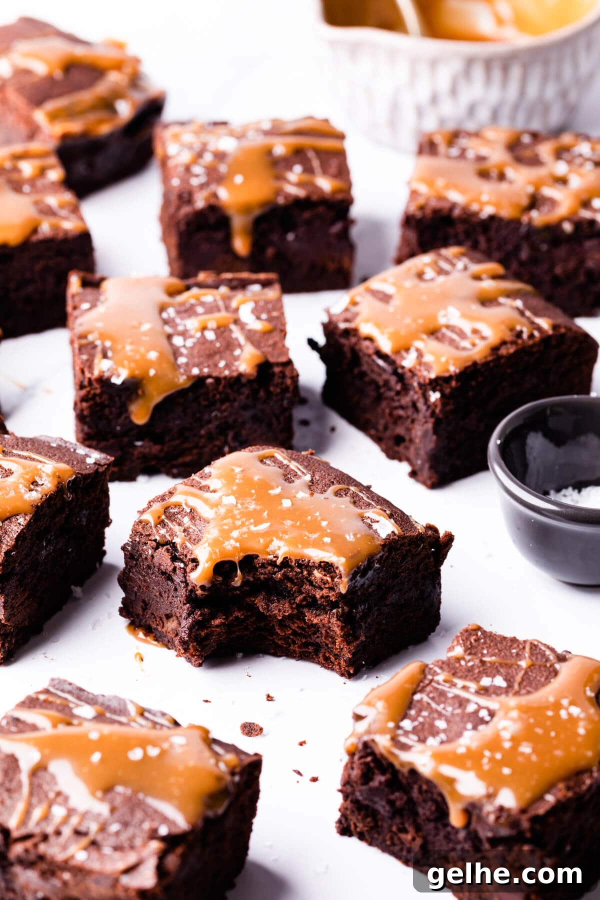 Guinness Chocolate Brownies with Rich Stout Flavor 9 square pieces of brownies drizzled with salted caramel with one brownie missing a bite.
