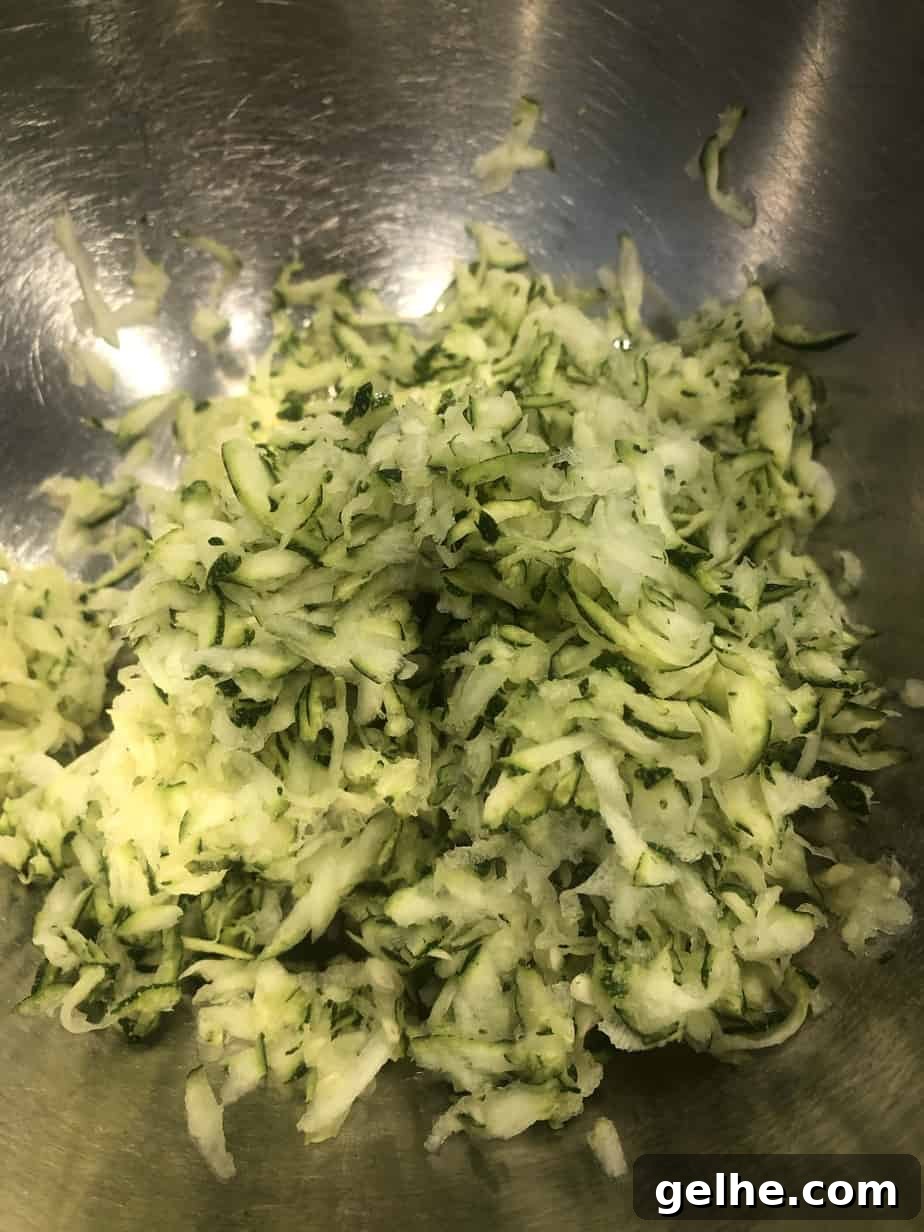 Crispy Cornmeal Zucchini Fritters with Garlic Herb Dip 4 overhead shot of shredded zucchini in a mixing bowl.