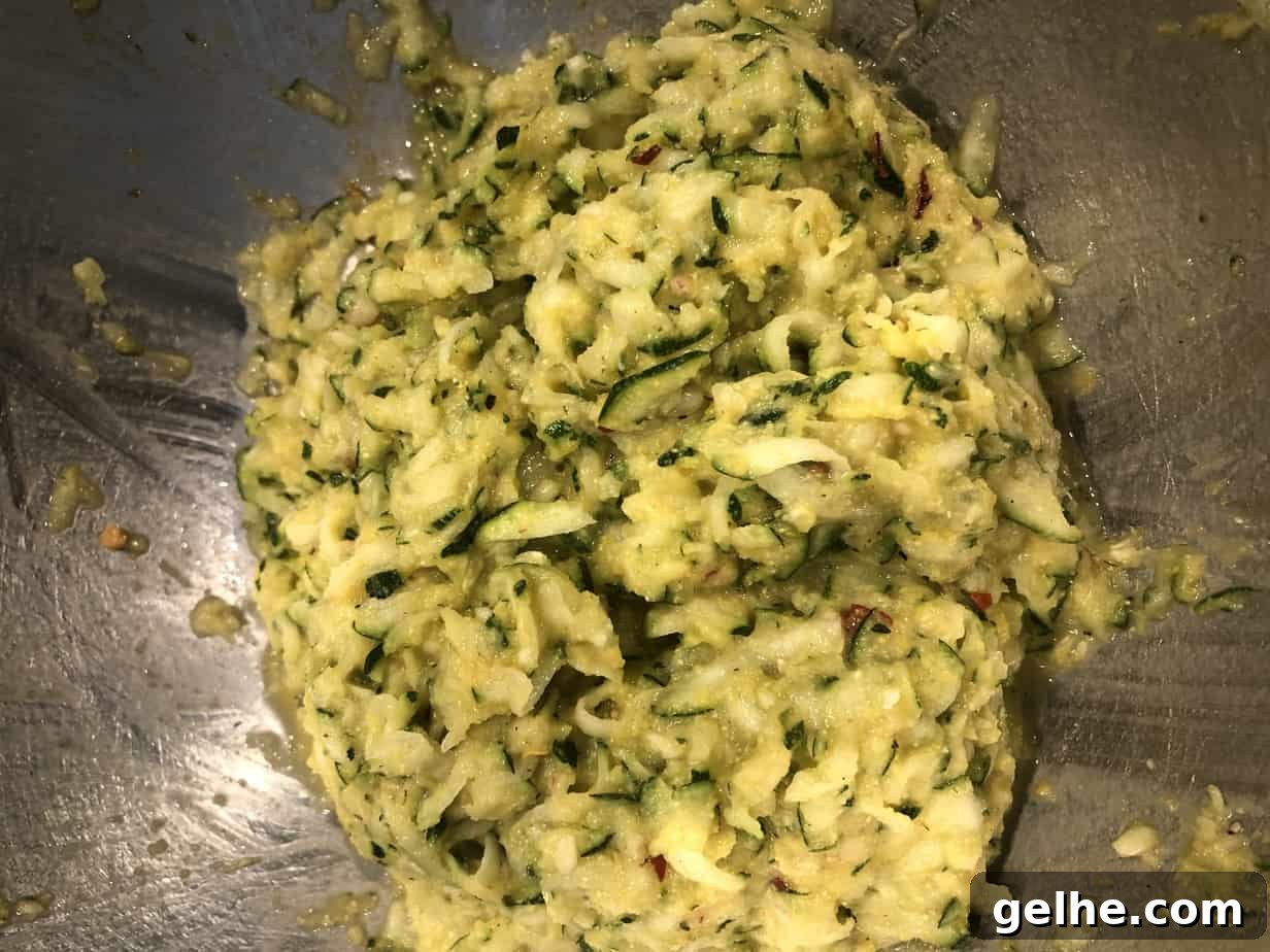 Crispy Cornmeal Zucchini Fritters with Garlic Herb Dip 5 overhead shot of shredded zucchini in a mixing bowl.