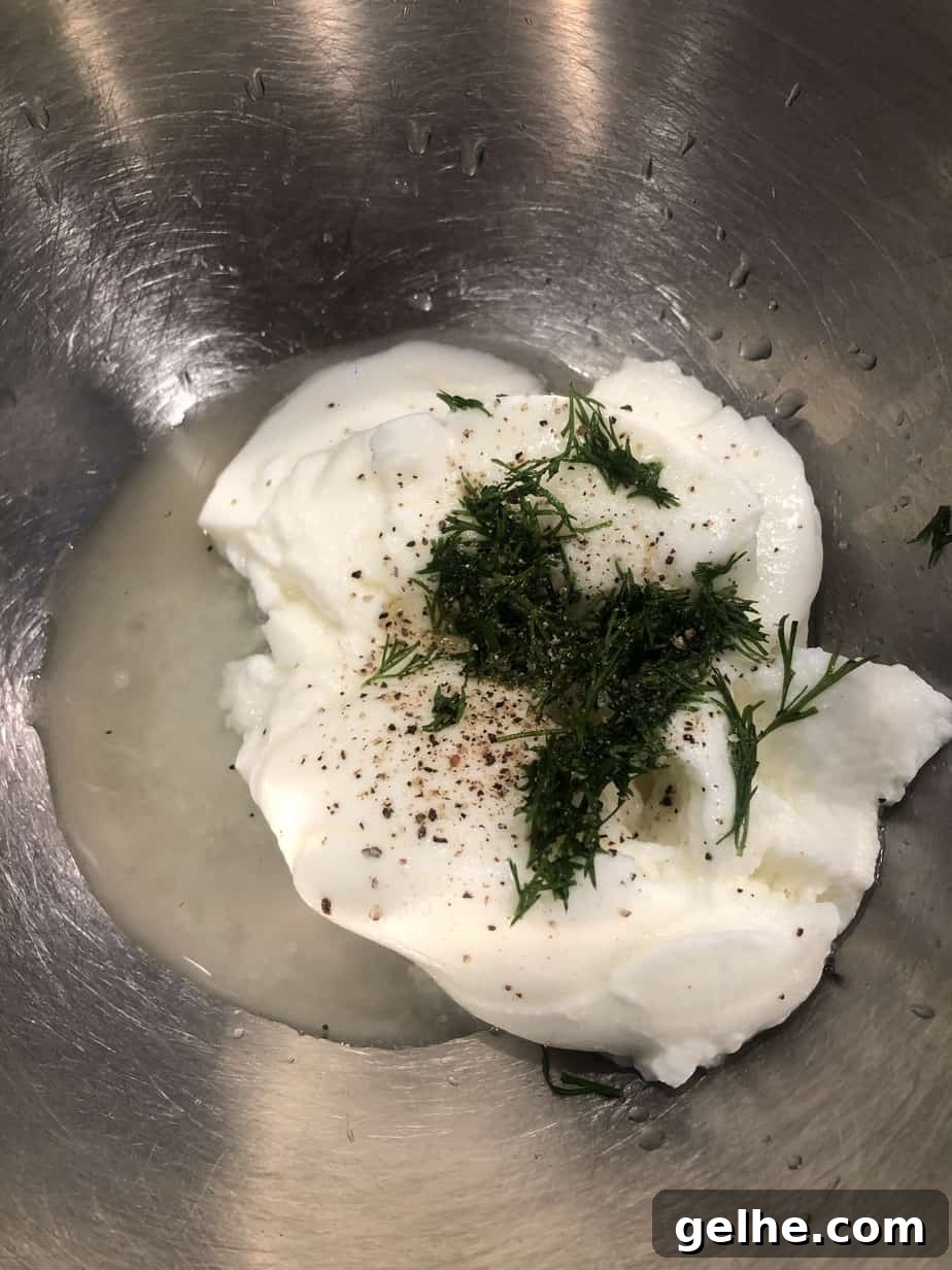 Crispy Cornmeal Zucchini Fritters with Garlic Herb Dip 6 overhead shot of yogurt dill sauce ingredients in mixing bowl.