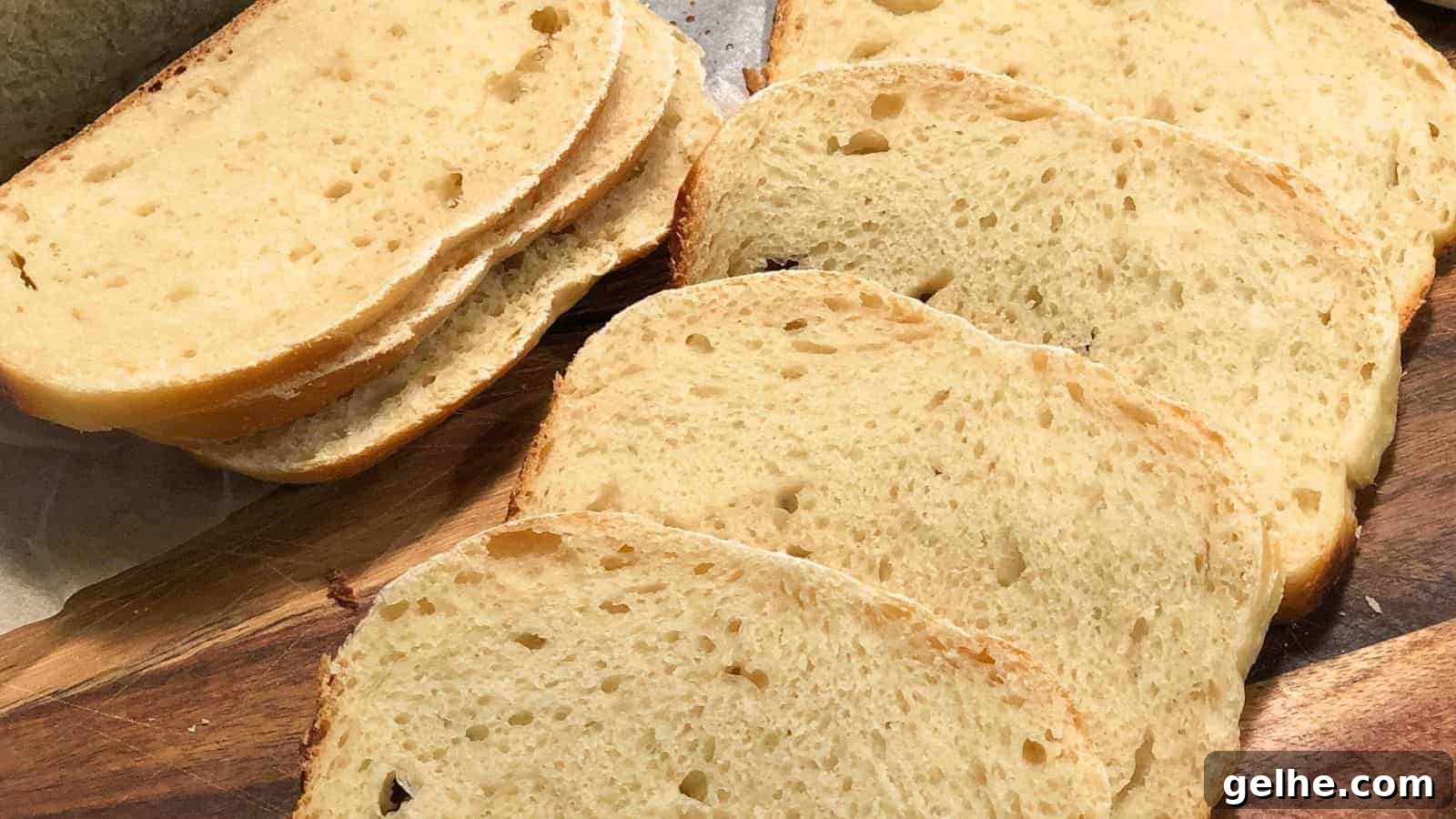 Seven slices of Sourdough Sandwich Bread arranged on a wooden cutting board.