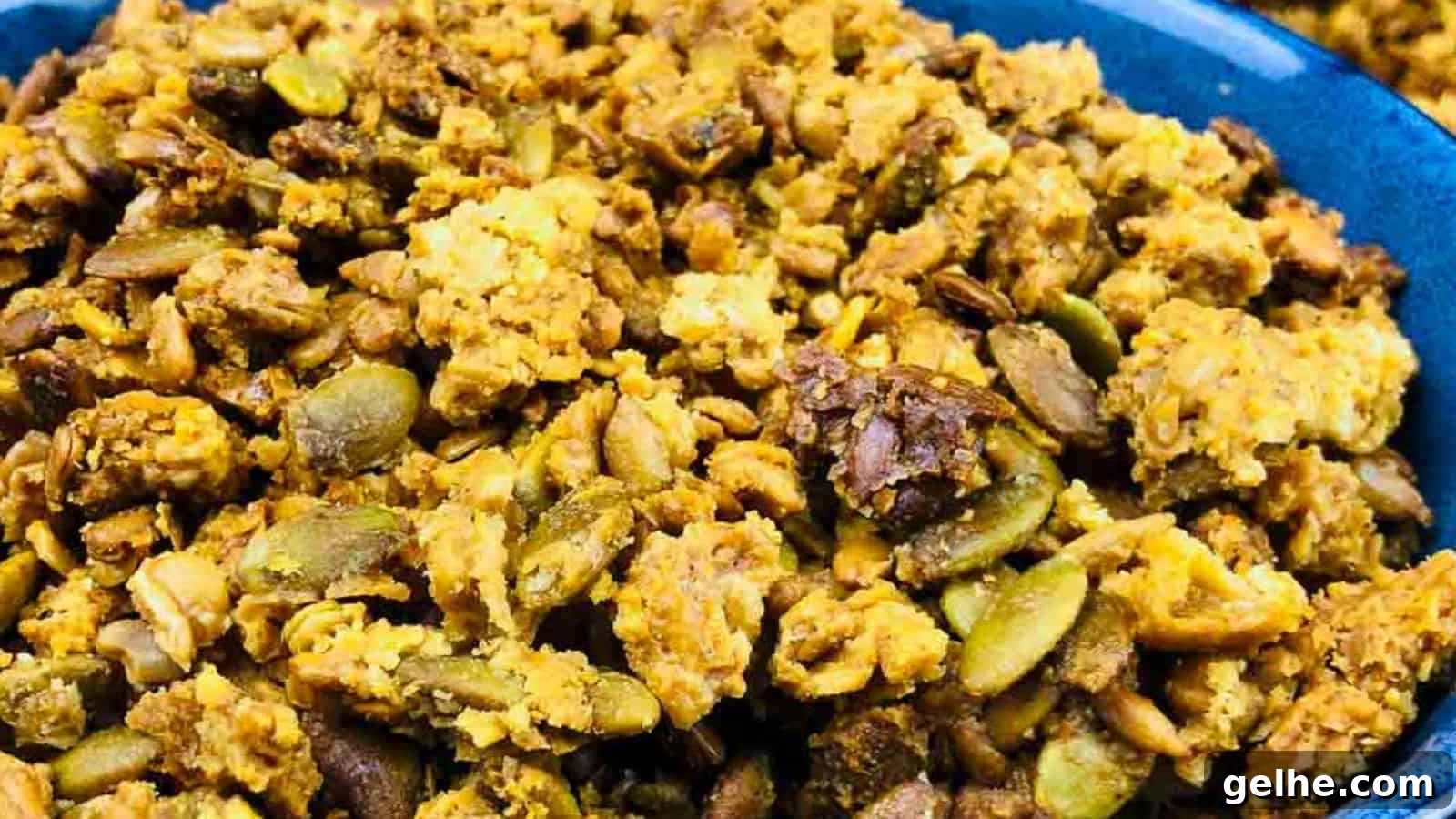 Close-up image of a bowl filled with granola, featuring a mix of nuts, seeds, and clusters of oats.