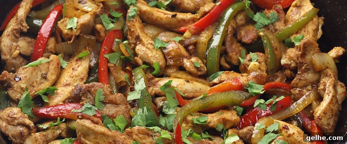 Skillet chicken fajitas with bell pepper veggies and garnish.