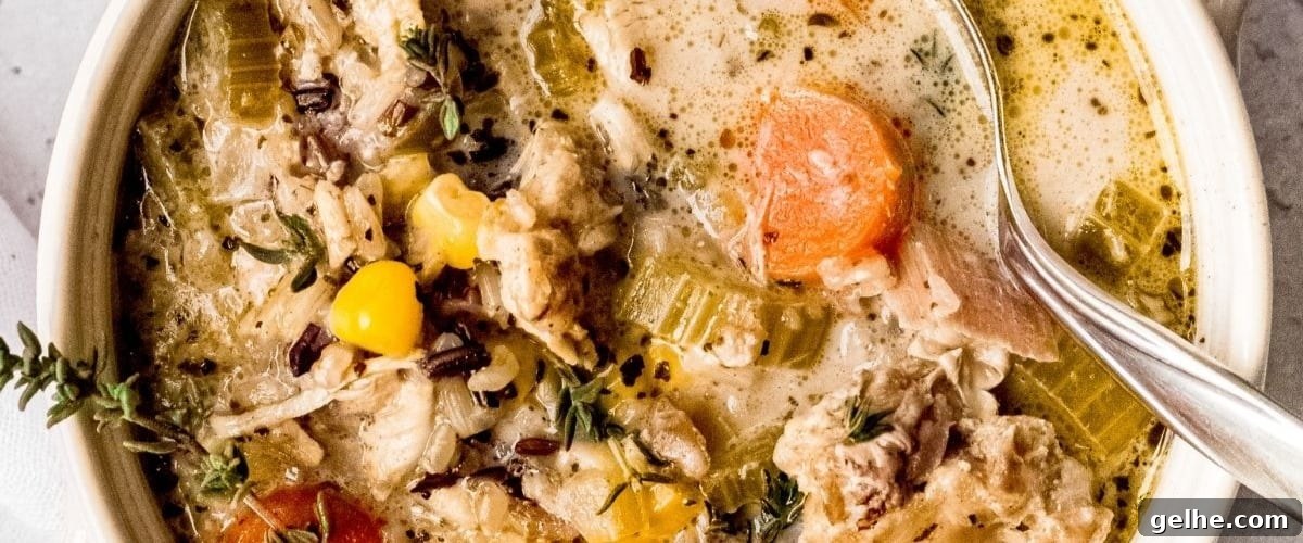 Instant pot chicken and rice soup in white bowl with garnish.