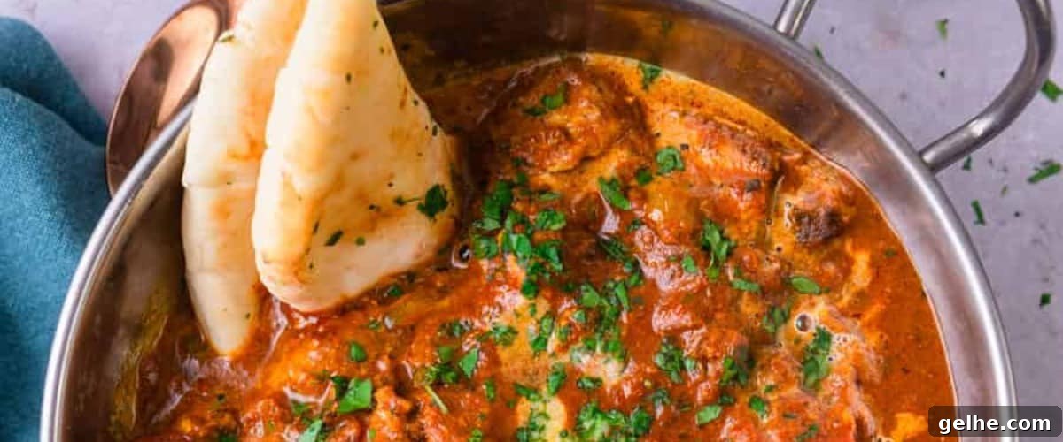 Chicken tikka masala with garnish and naan.