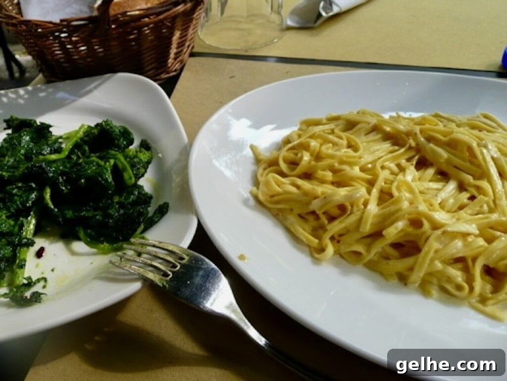 Plates of pasta al limone and sautéed spinach at a restaurant in Rome.