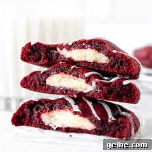 Red velvet cheesecake cookies, broken in half and stacked on top of each other