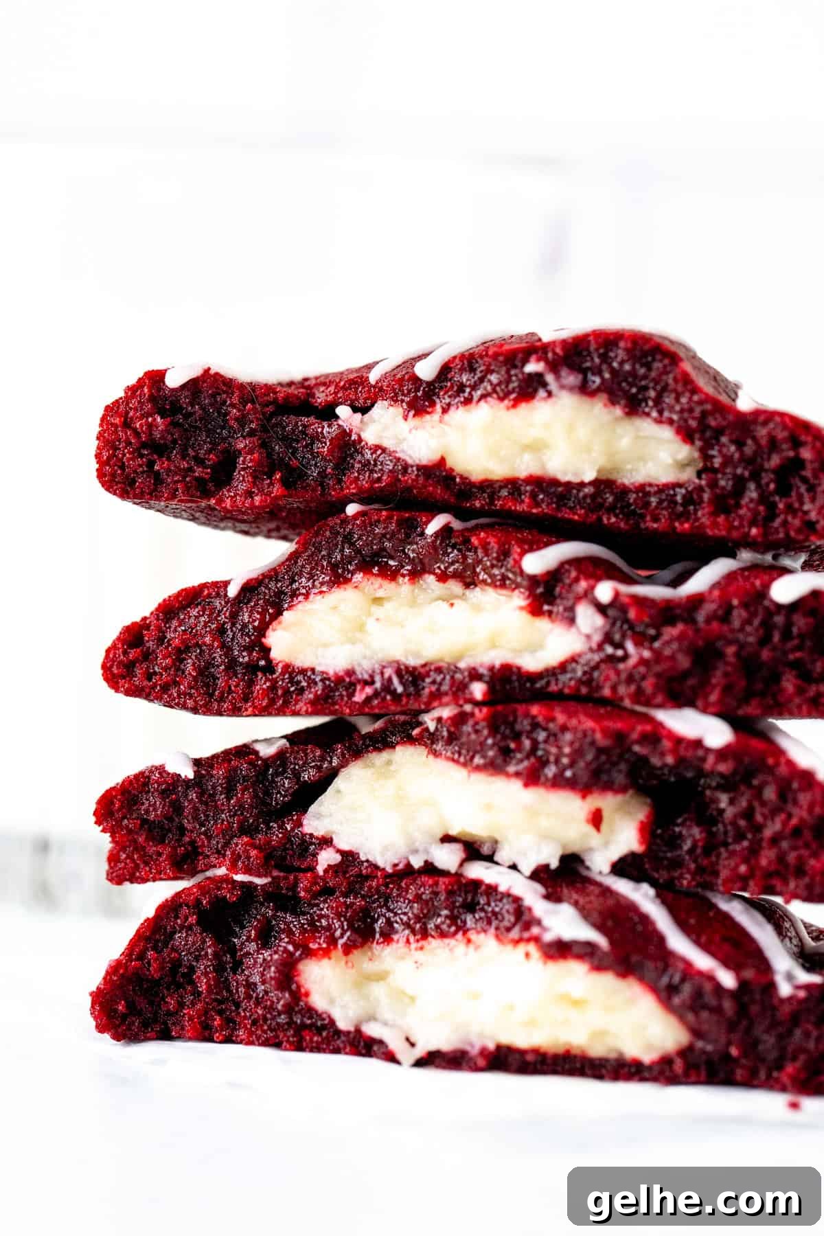 cheesecake stuffed red velvet cookies, broken in half and stacked on top of each other