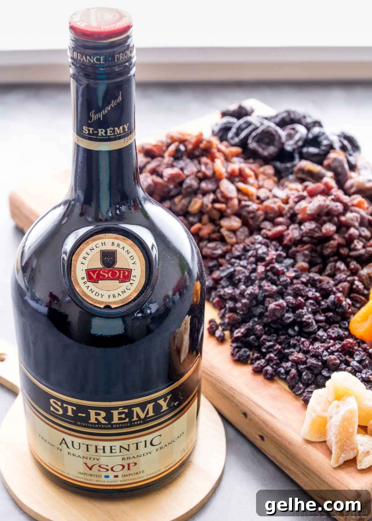 A bottle of brandy with dried fruits in the background.