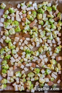 top down view of cubed potatoes and romanesco on a sheet pan