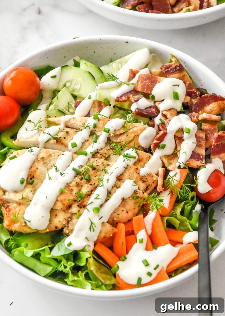 Chicken Bacon Ranch Salad Recipe: Creamy, Crunchy Weeknight Favorite 11 close up of a chicken bacon ranch salad in a bowl with a fork.