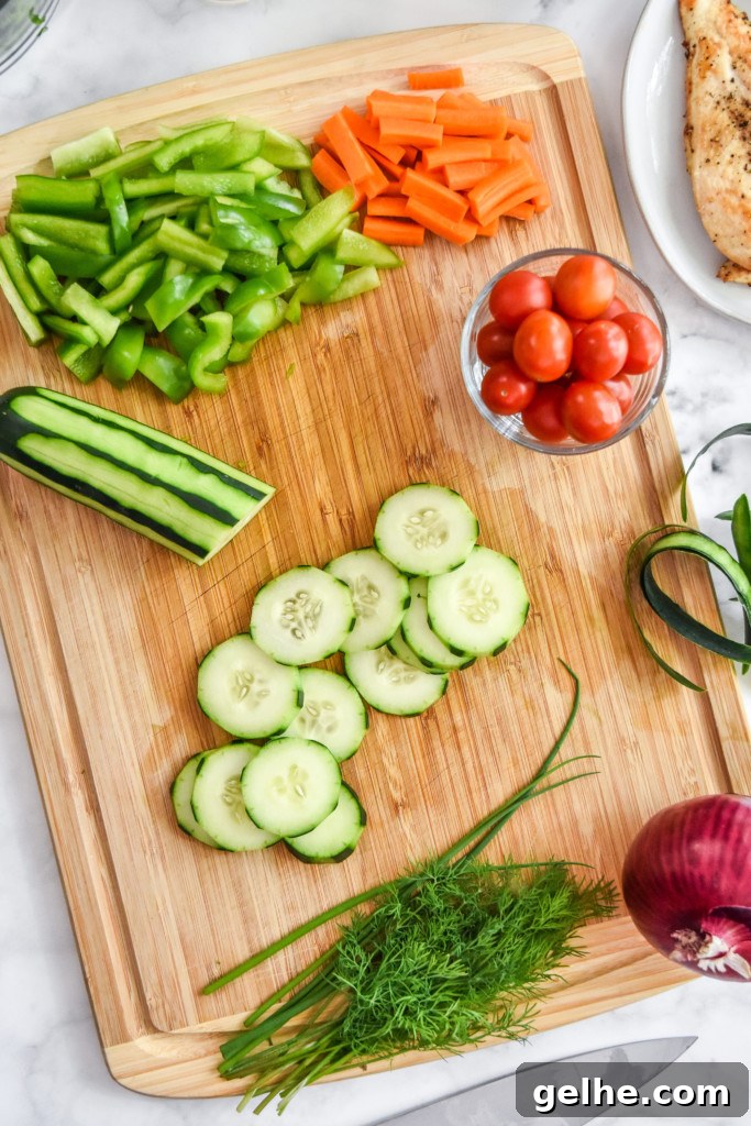 Chicken Bacon Ranch Salad Recipe: Creamy, Crunchy Weeknight Favorite 7 cutting the cucumber and veggies on a cutting board to make chicken bacon ranch salad.