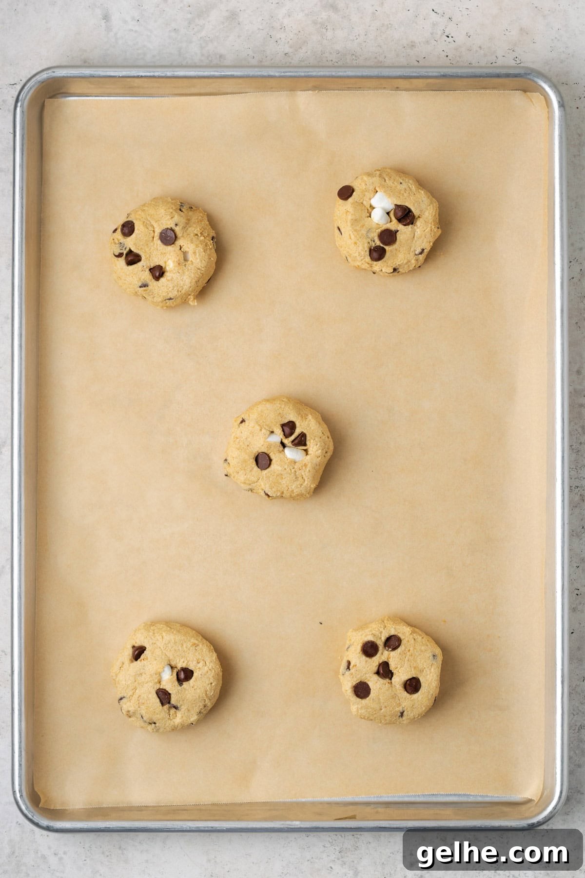 Five s'mores chocolate chip cookies on a baking sheet.