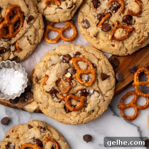 A batch of caramel pretzel chocolate chip cookies scattered on a wood tray.