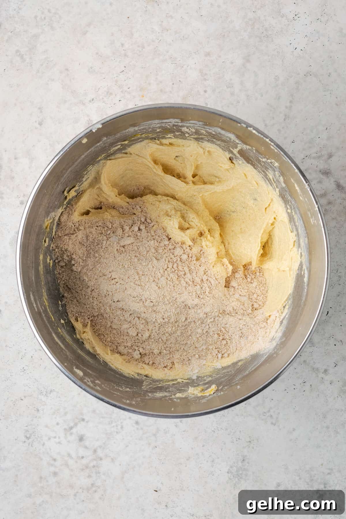 Dry ingredients being added to the partially mixed cookie dough. 