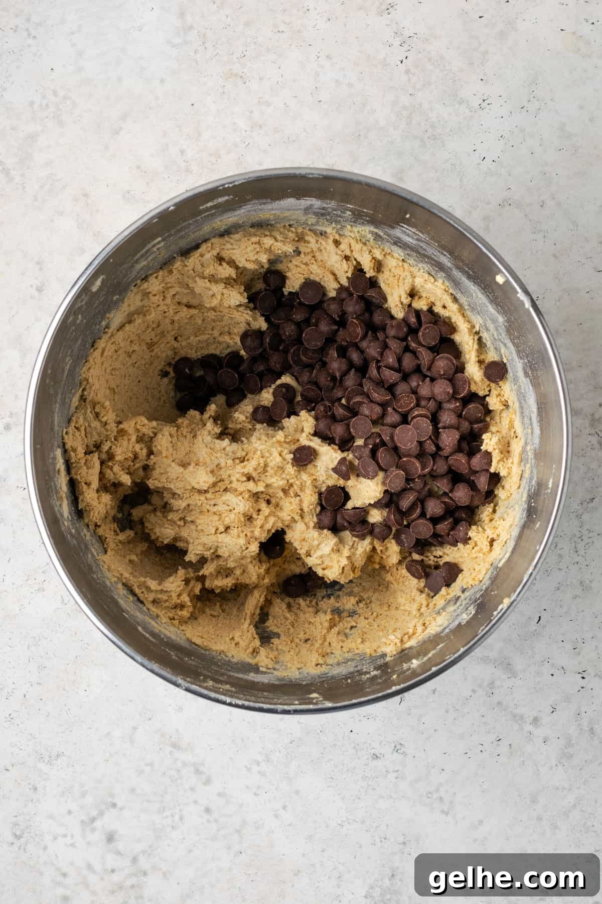 Chocolate chips being mixed into the cookie dough.