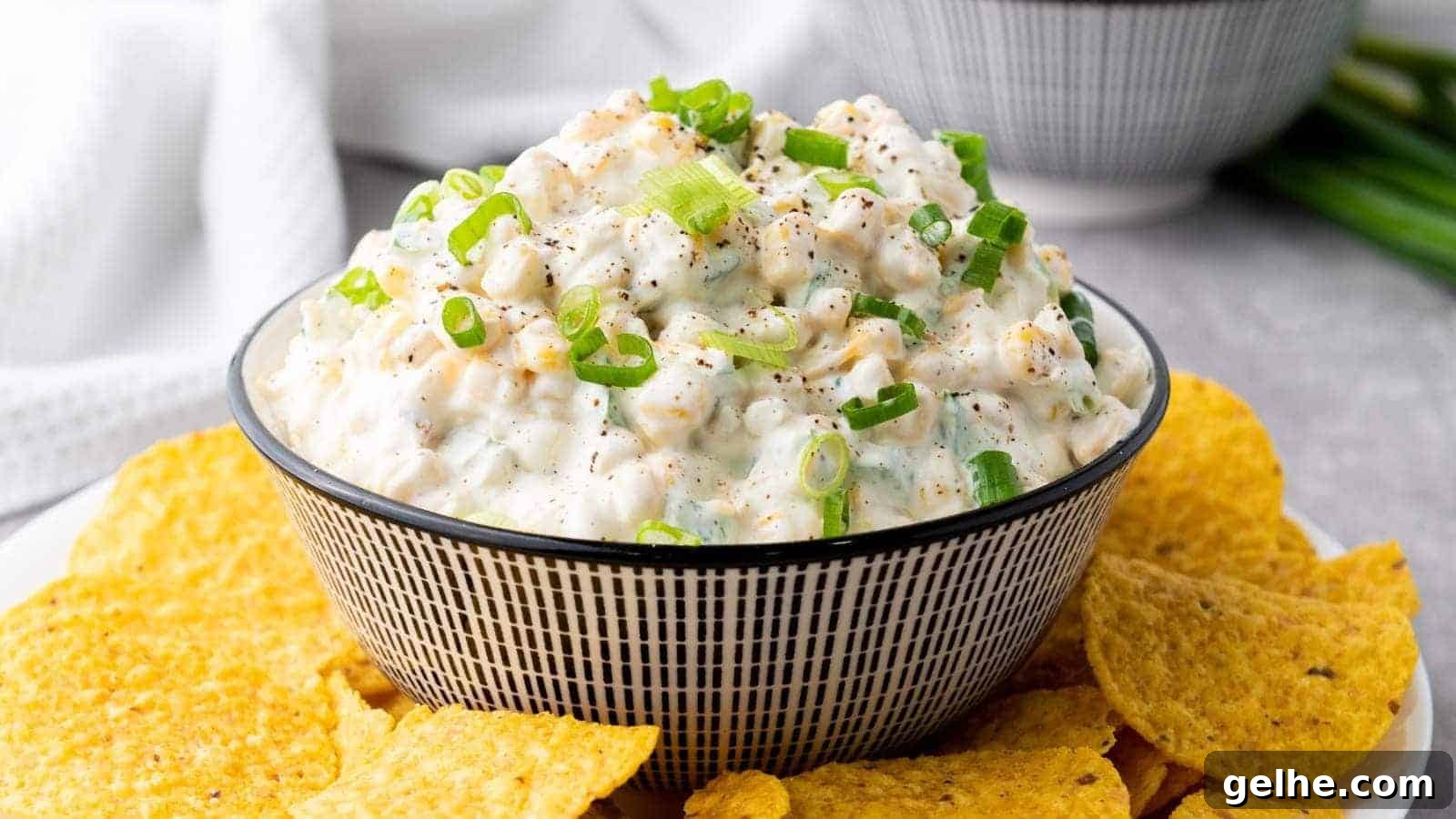 21 Labor Day Picnic Recipes for a Crowd: Ultimate Menu Ideas 11 A creamy corn dip topped with chopped green onions, surrounded by tortilla chips.
