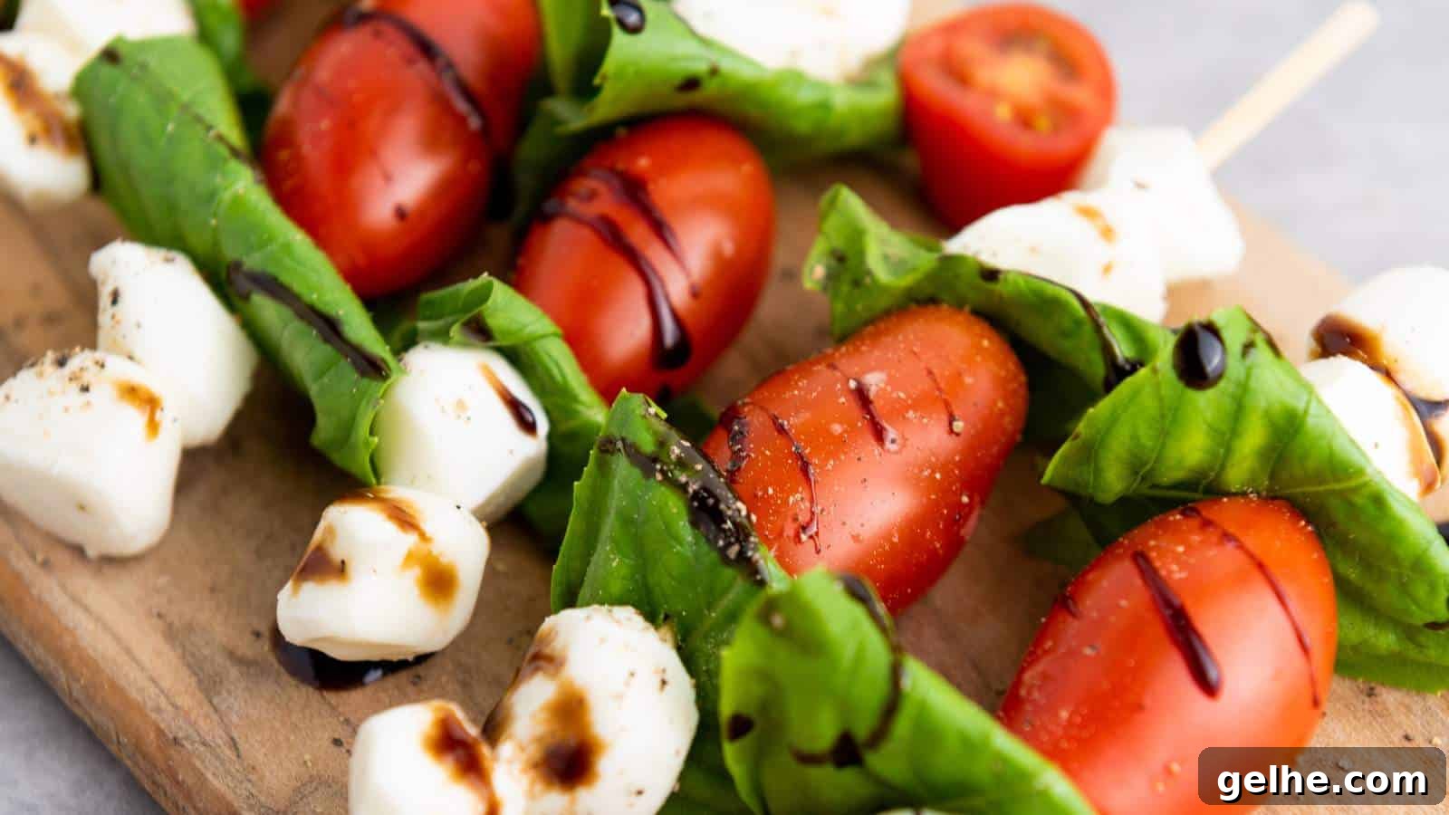 21 Labor Day Picnic Recipes for a Crowd: Ultimate Menu Ideas 17 Caprese skewers drizzled with balsamic glaze on a wooden board.