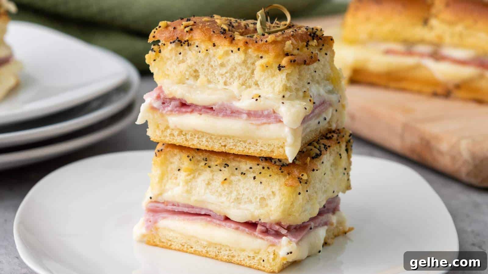 21 Labor Day Picnic Recipes for a Crowd: Ultimate Menu Ideas 3 Two stacked sandwiches with layers of ham and melted cheese between thick slices of seasoned bread, served on a white plate.