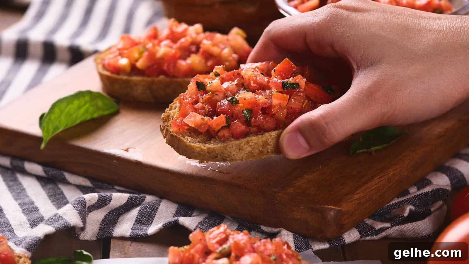 21 Labor Day Picnic Recipes for a Crowd: Ultimate Menu Ideas 21 A person's hand picking up a slice of bruschetta al pomodoro.
