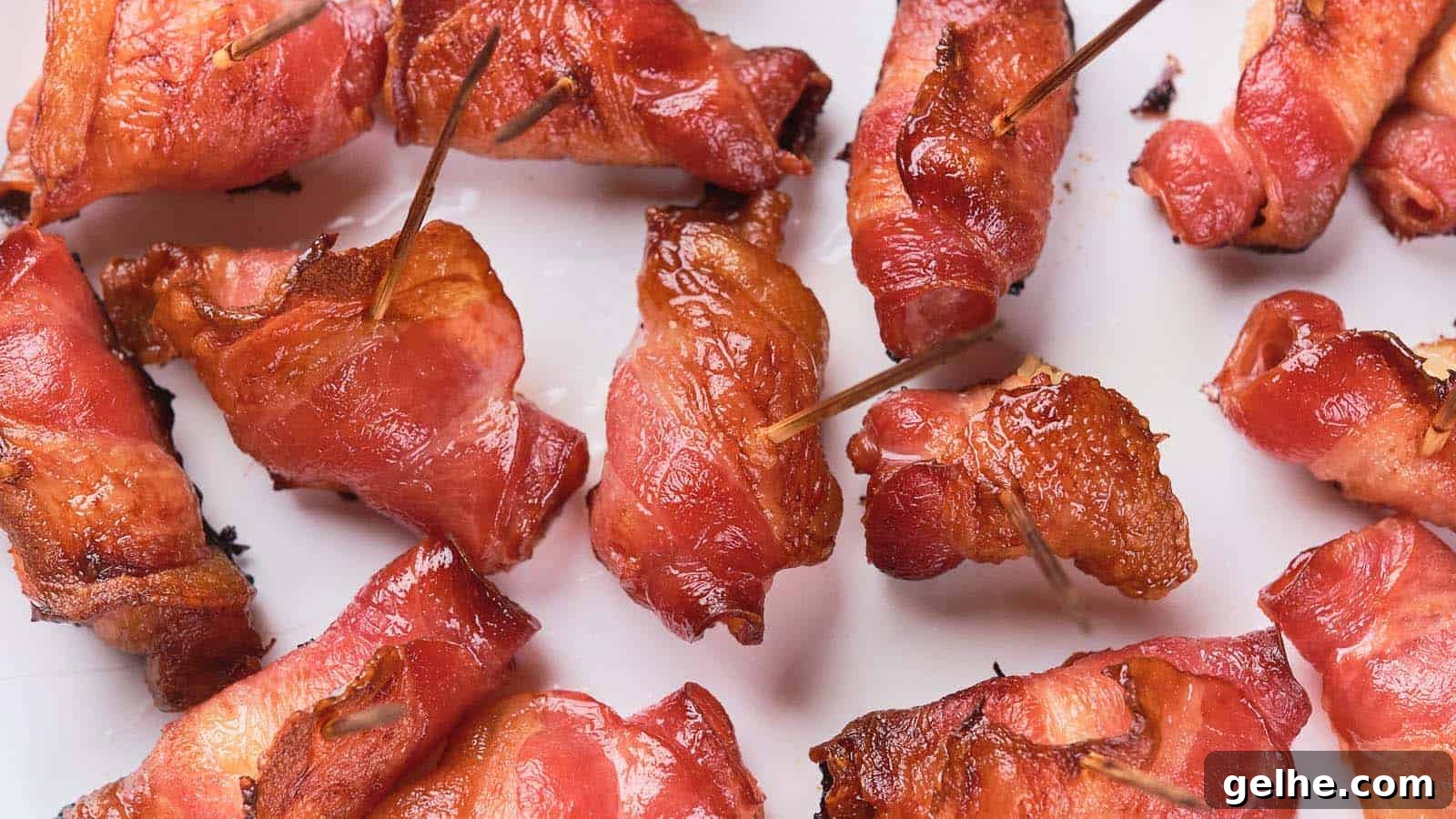 21 Labor Day Picnic Recipes for a Crowd: Ultimate Menu Ideas 6 Close-up of several bacon-wrapped items secured with toothpicks, arranged on a white surface.