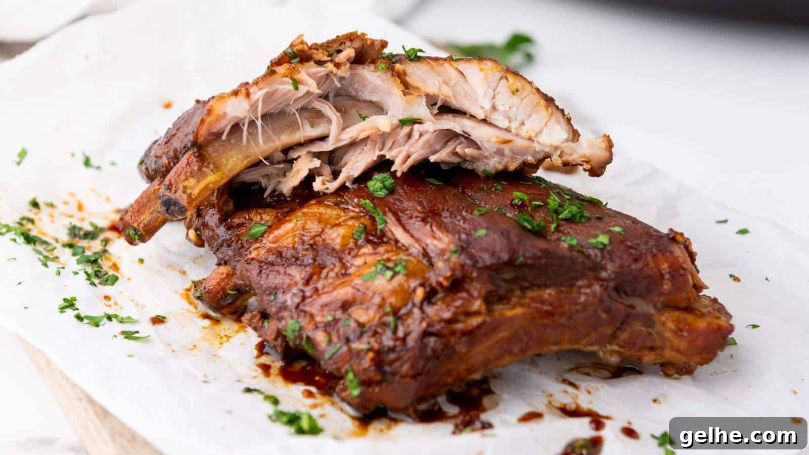 21 Labor Day Picnic Recipes for a Crowd: Ultimate Menu Ideas 8 Close-up of cooked baby back ribs on parchment, garnished with chopped parsley.