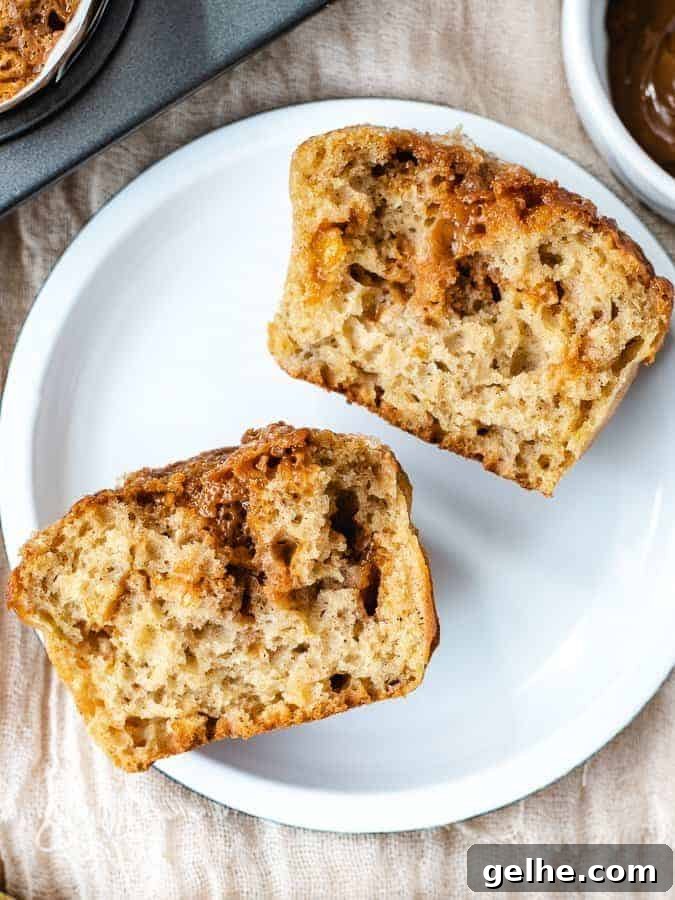 Overhead shot of banana dulce de leche muffin cut in half on a white plate