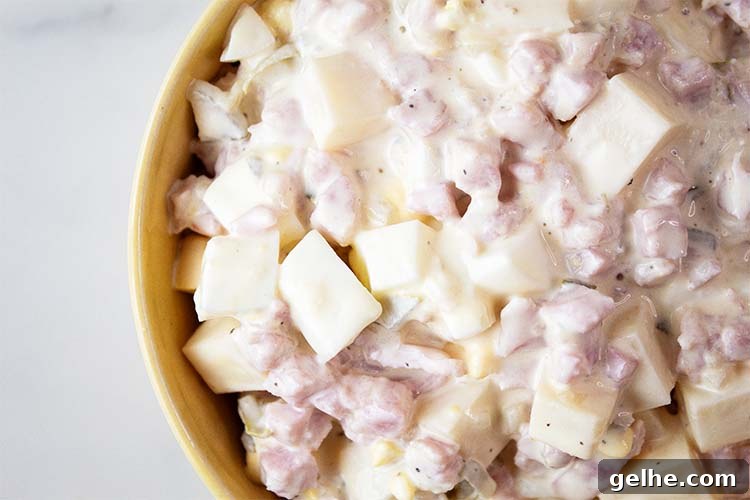 overhead view of ham and cheese salad ready to serve in a yellow bowl