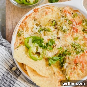 Baked Cheddar Jalapeño Dip with Crispy Panko Topping 12 Baked cheddar jalapeño dip in white skillet garnished with jalapeño slices and two tortilla chips in.