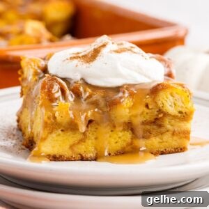 Slice of Pumpkin Bread Pudding on a plate with whipped cream on top
