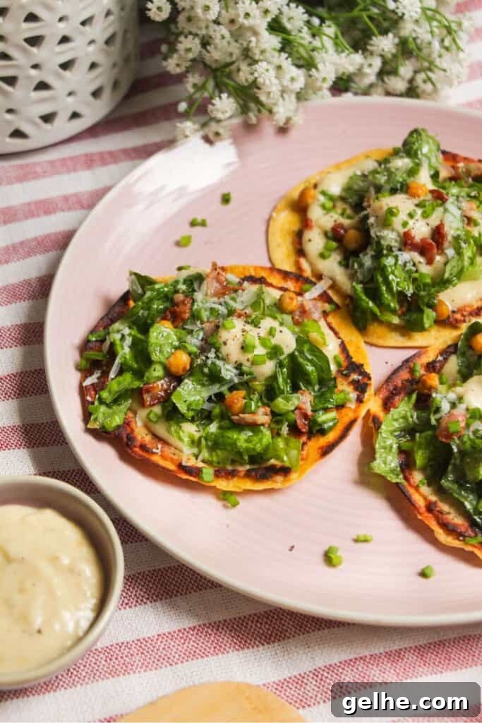 Three chicken Caesar tacos on a pink plate.