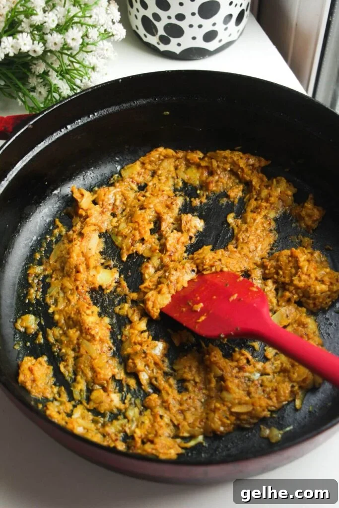 Cooking spices and onion in a large pan.