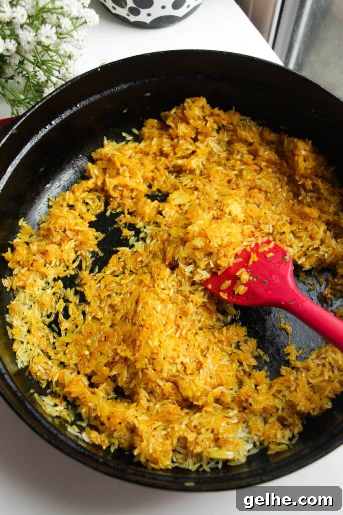 Stirring spices, onion and rice in a large pan.