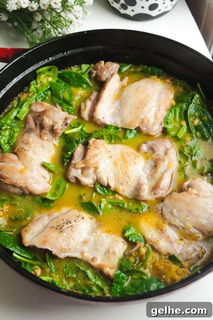 Cooked chicken thighs nestled in stock and rice.