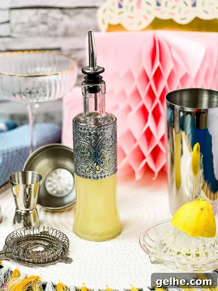 Fresh-Squeezed Lemon Juice: A Complete Guide to Making and Using It 2 Bottle filled with freshly squeezed lemon juice fitted with a pouring spout, surrounded by cocktail making tools.