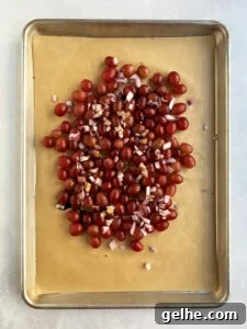 Uncooked grapes on baking tray with liquid poured over.