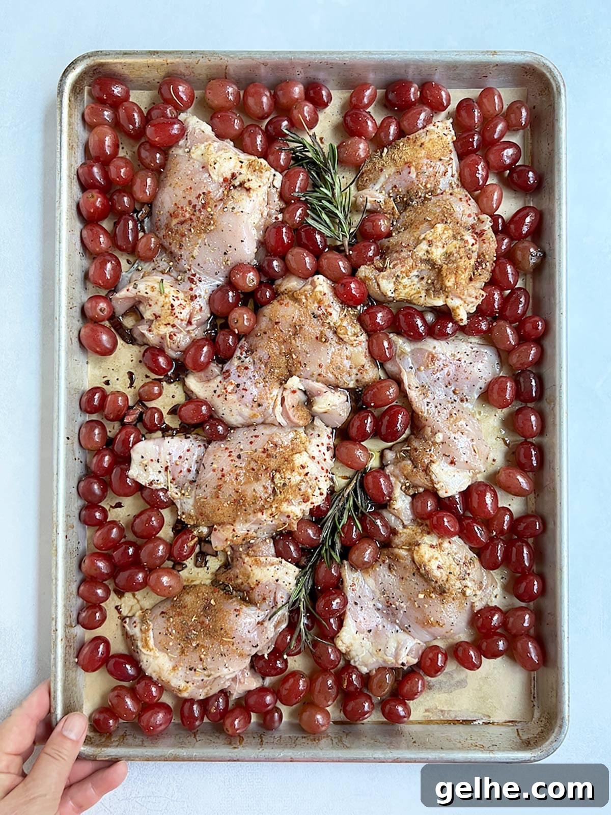Grapes and chicken on tray uncooked.