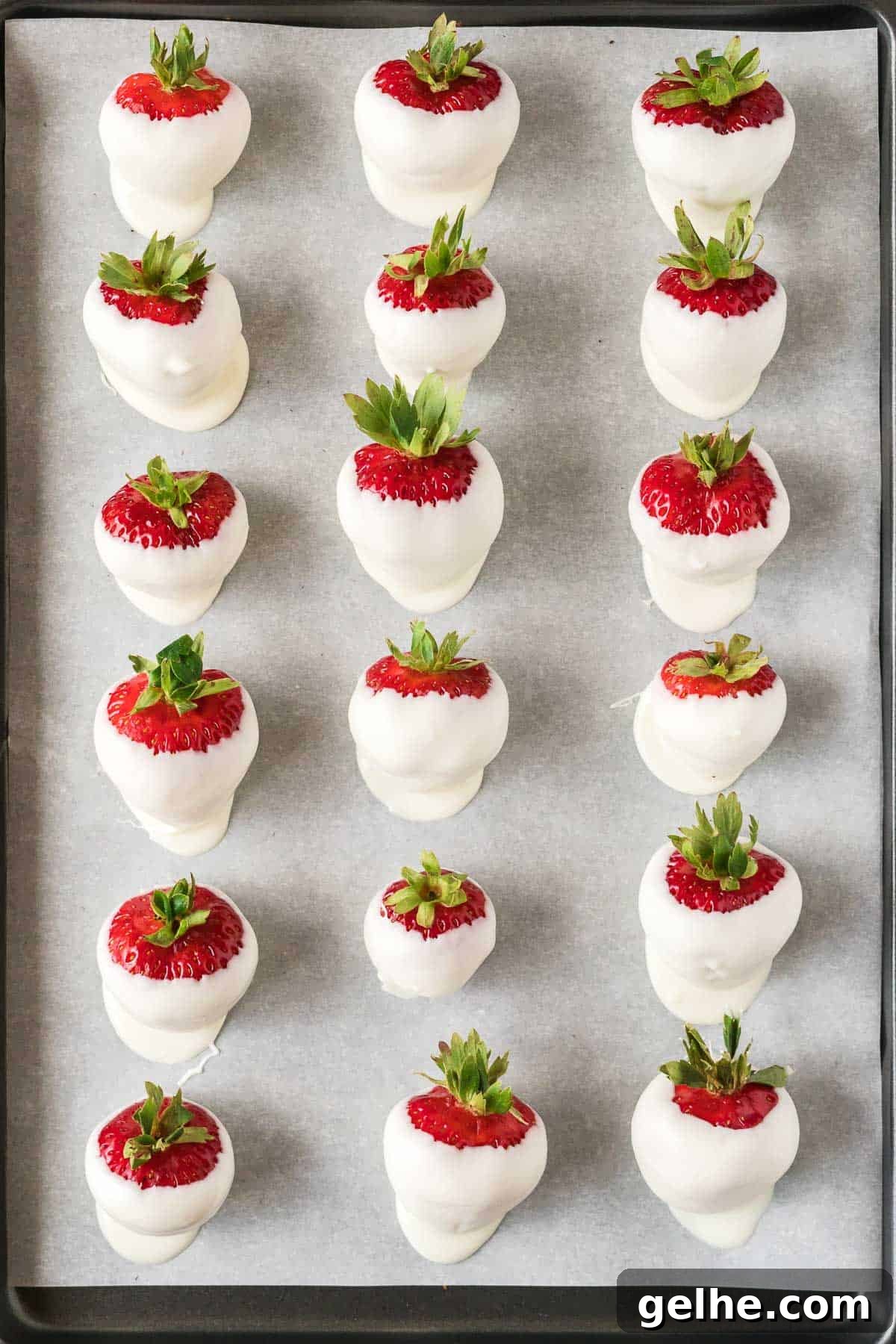 dipped white chocolate strawberries on a baking sheet