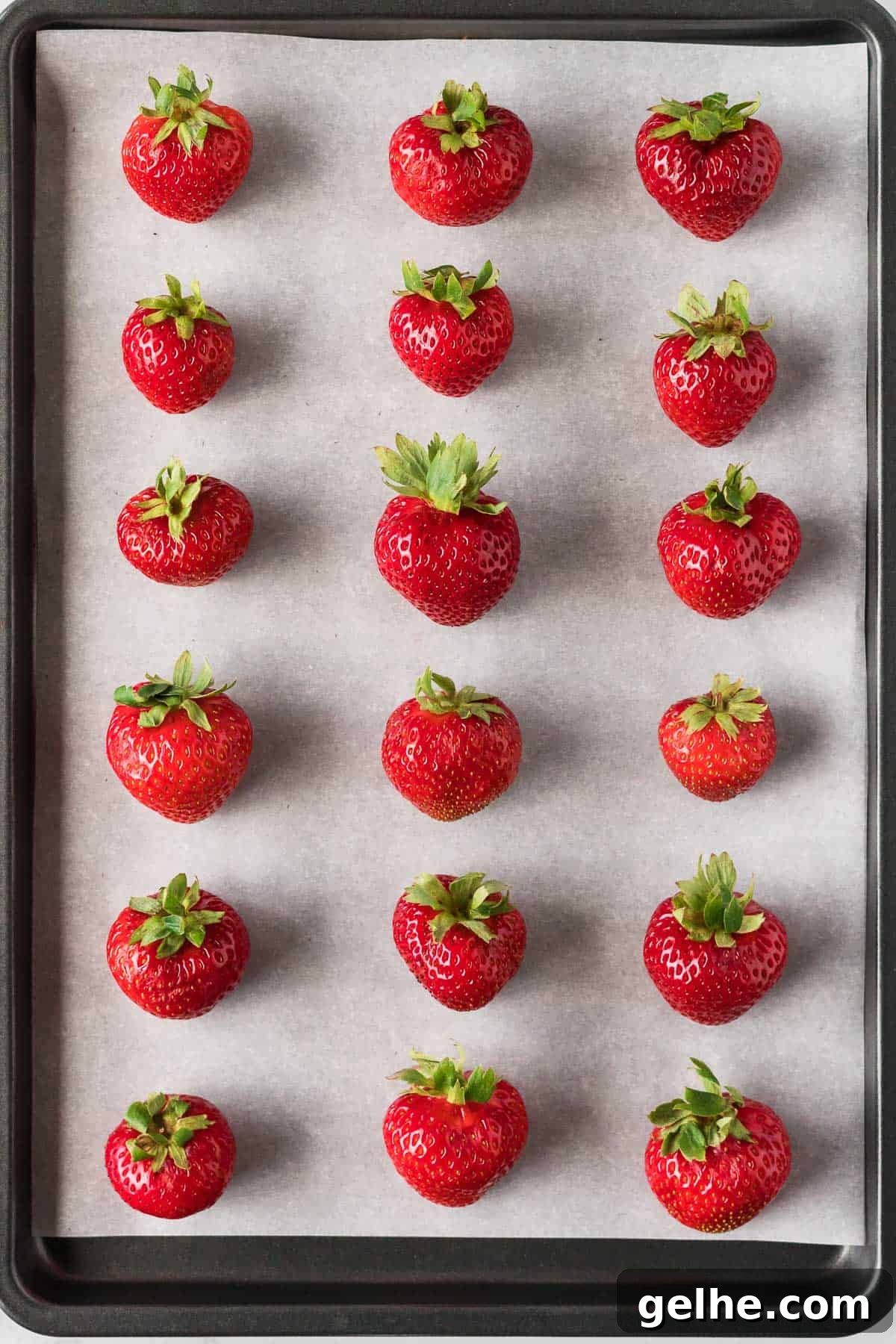 strawberries on a parchment paper lined baking sheet