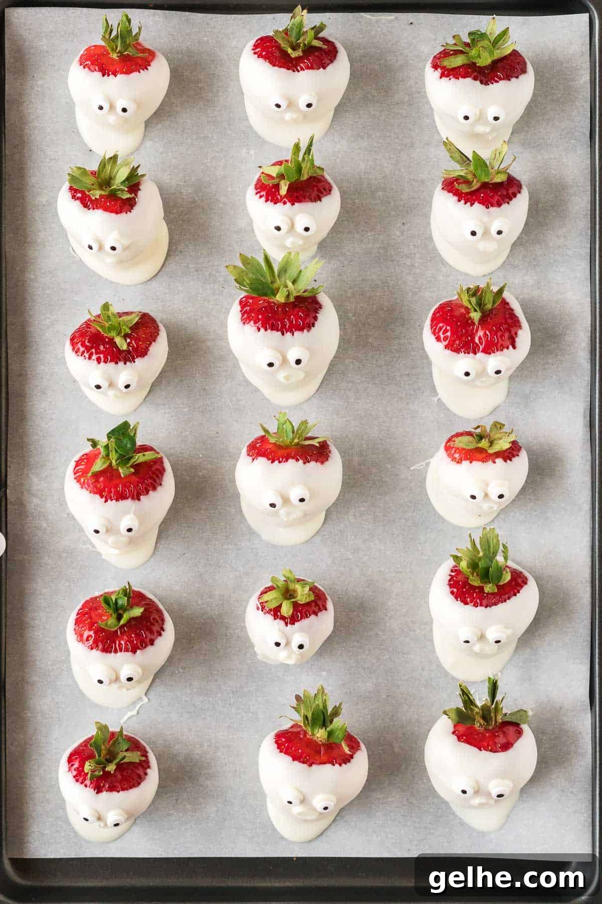 strawberry ghosts with candy eye balls on a baking sheet