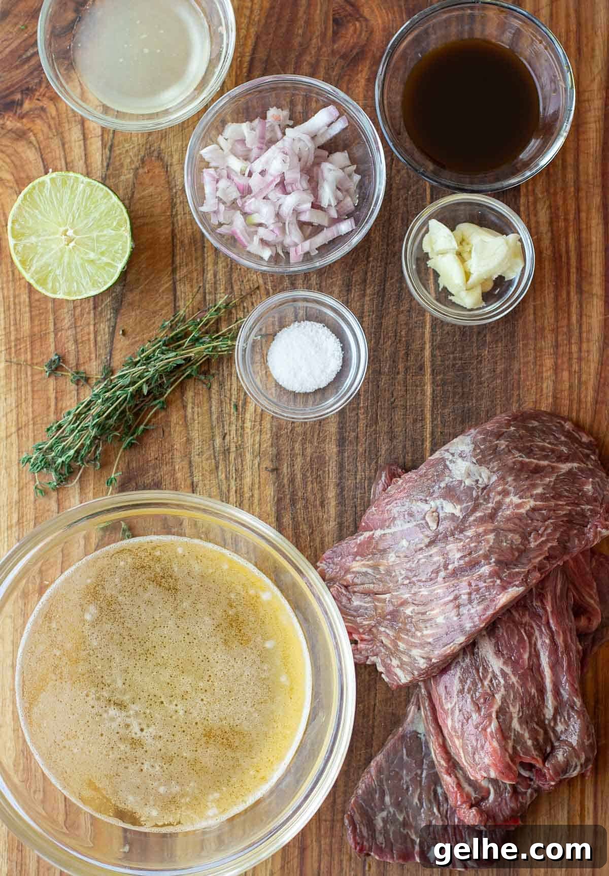 Beer Marinade Recipe for Grilled Bavette Steak 3 Beer Beef Marinade ingredients on a cutting board including beer, lime juice, Worcestershire, garlic, shallots, and bavette steak.
