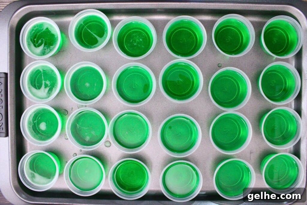 pour grinch shot jello mixture into plastic shot glasses