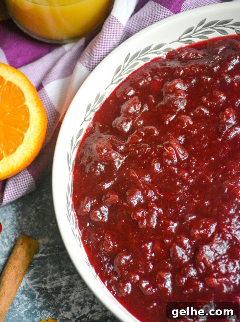 Quick Instant Pot Cranberry Sauce Recipe for Thanksgiving 3 Instant pot cranberry sauce shown in a large shallow white serving dish with a wooden spoon for serving