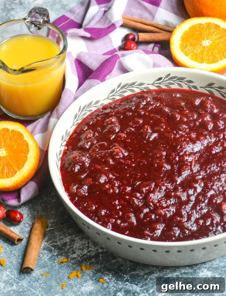 Quick Instant Pot Cranberry Sauce Recipe for Thanksgiving 4 Instant pot cranberry sauce shown in a large shallow white serving dish with a wooden spoon for serving