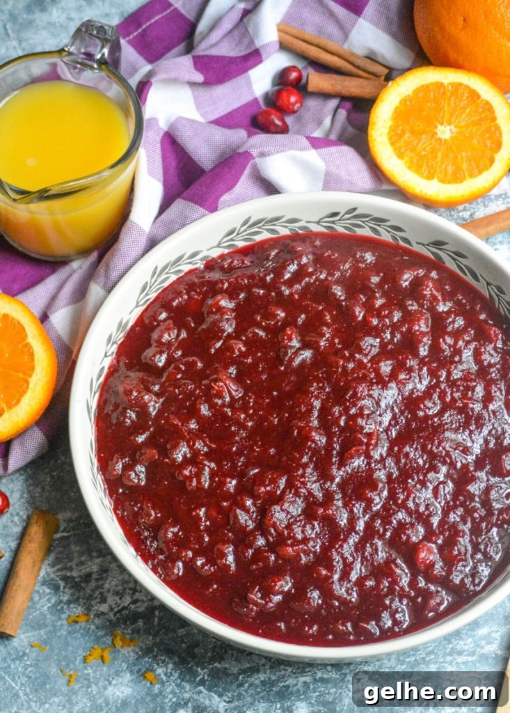 Quick Instant Pot Cranberry Sauce Recipe for Thanksgiving 6 Instant pot cranberry sauce shown in a large shallow white serving dish with a wooden spoon for serving