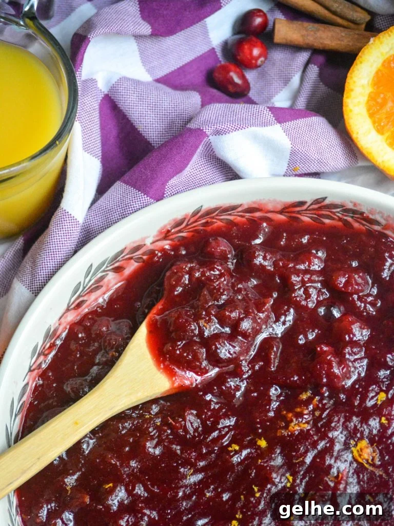 Quick Instant Pot Cranberry Sauce Recipe for Thanksgiving 7 Instant pot cranberry sauce shown in a large shallow white serving dish with a wooden spoon for serving