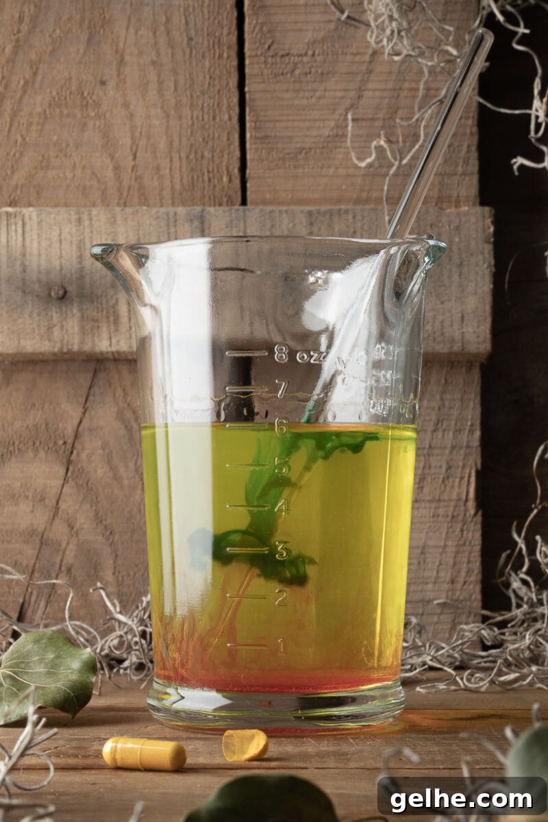 Blacklight Swamp Shot Recipe: Glow-In-The-Dark Party Drink 6 strawberry rum in a measuring cup with vitamin b2, red food coloring, and green food coloring