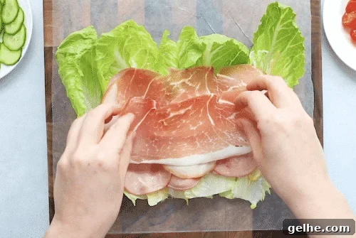 overhead view of lettuce wrap with deli meat on a wooden board